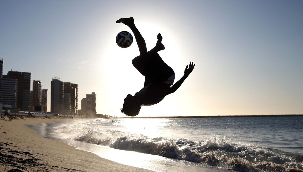 A boy plays soccer on Iracema Beach in Fortaleza, Brazil, on the eve of the 2014 FIFA World Cup. Getty photo.