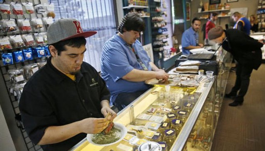 Employees roll joints behind the sales counter at Medicine Man marijuana dispensary in Denver. (AP)