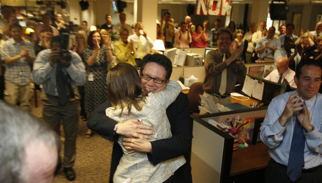 PolitiFact Founder Bill Adair receives congratulations from Reporter and Researcher Angie Drobnic Holan in the newsroom of the St. Petersburg Times.