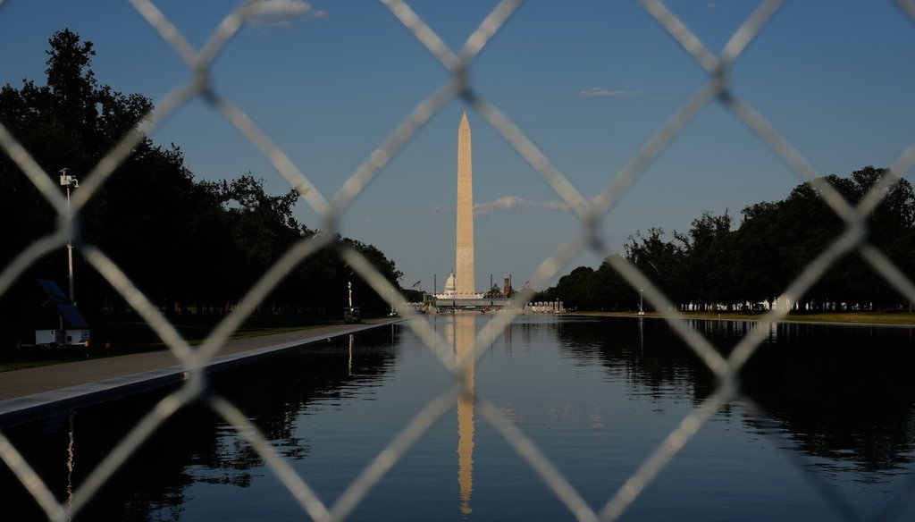 The Washington Monument, reflected in the Lincoln Memorial Reflecting Pool, is seen behind fencing, Thursday, June 25, 2026, in Washington. (AP Photo/Carolyn Kaster)