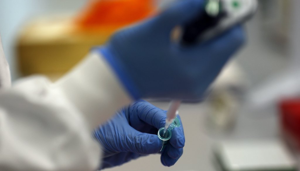 A lab assistant uses a pipette to prepare Coronavirus RNA for sequencing at the Wellcome Sanger Institute that is operated by Genome Research in Cambridge, March 4, 2021. (AP)