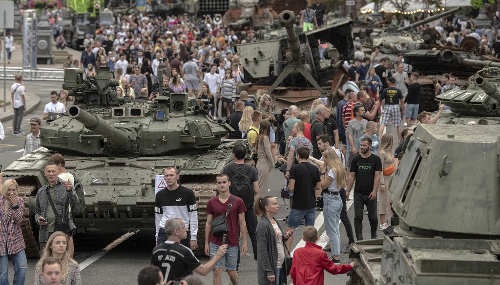 Ukrainians visit an avenue where destroyed Russian military vehicles have been displayed in Kyiv, Ukraine, on Aug. 20, 2022.