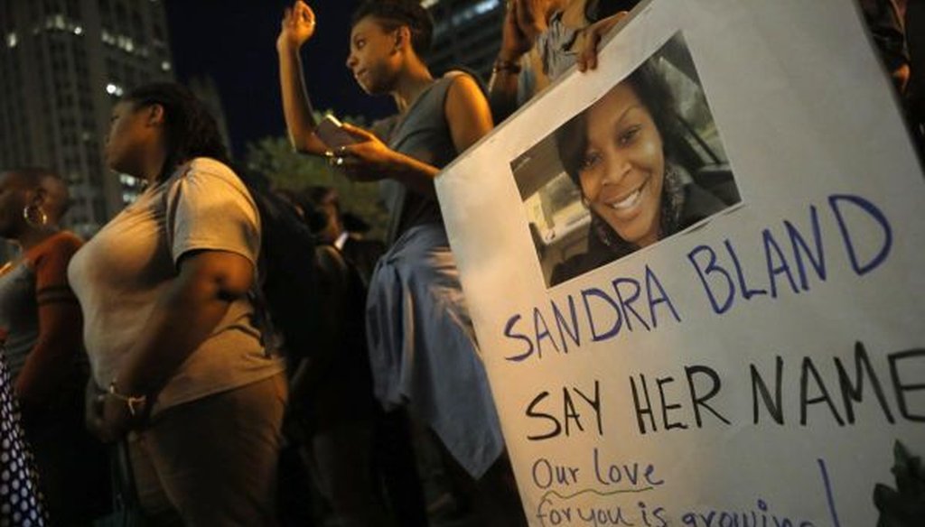 A demonstrator holds a sign for Sandra Bland during a July 28, 2015, vigil in Chicago. Bland died in a Texas county jail after a traffic stop that escalated into a physical confrontation. (AP photo | Christian K. Lee)