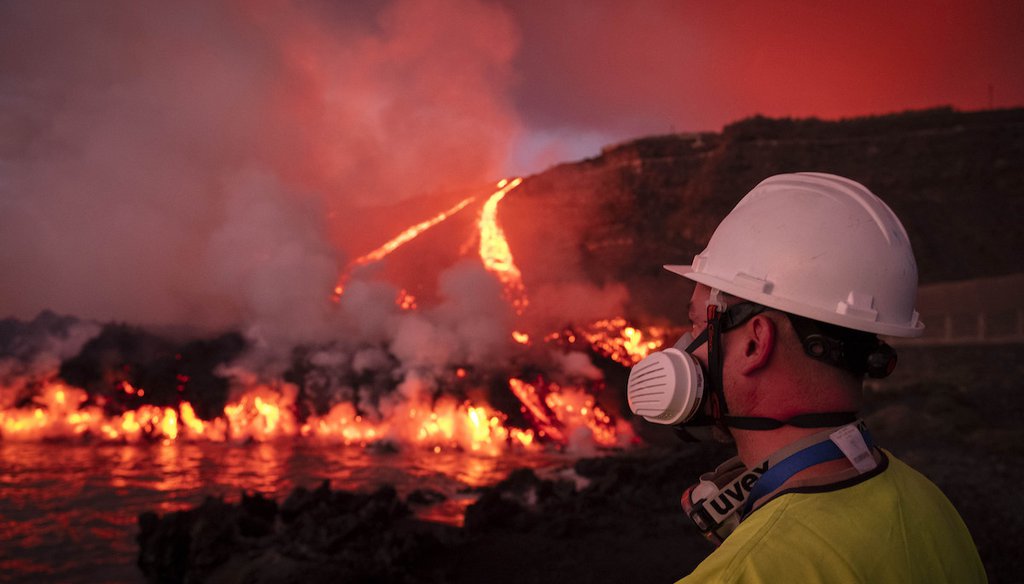 A scientist watches lava flows from a volcano reach the sea on the Canary island of La Palma, Spain, Nov. 11, 2021. (AP)