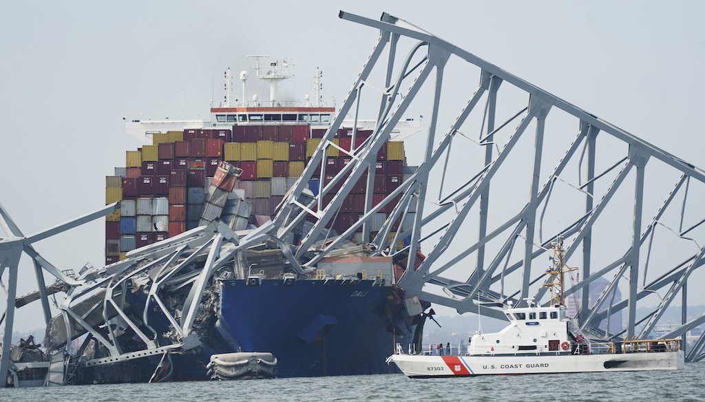 A Coast Guard cutter passes a cargo ship that is stuck under the part of the structure of the Francis Scott Key Bridge March 26, 2024, in Baltimore, Md. (AP)