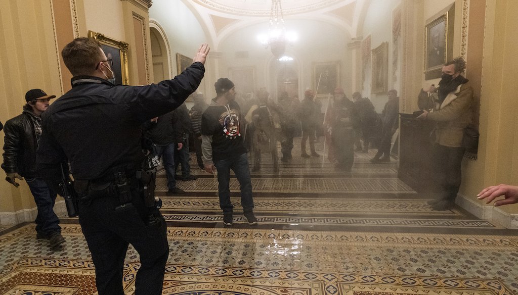 Smoke fills the walkway outside the Senate Chamber as rioters are confronted by U.S. Capitol Police officers inside the Capitol in Washington, Jan. 6, 2021. (AP)
