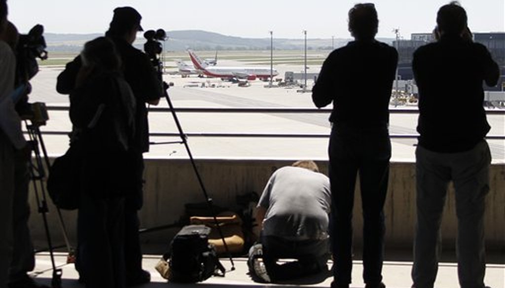 Media take pictures of a U.S., front, and a Russian plane, rear, believed to be carrying candidates for a 14-person spy swap as part of the largest spy swap since the Cold War have parked on the tarmac at Vienna's Schwechat airport, on July 9, 2010. (AP)