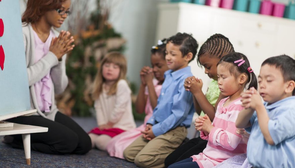 A group of children prays in this stock photo. (iStockphoto.com)