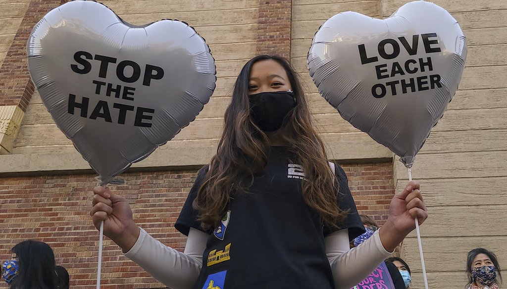 Chinese-Japanese American student Kara Chu, 18, holds a pair of heart balloons for a rally to raise awareness of anti-Asian violence outside the Japanese American National Museum in Little Tokyo in Los Angeles Saturday, March 13, 2021. (AP)