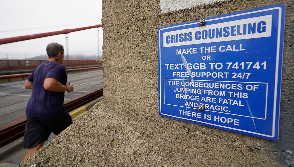 A man jogs past a sign about crisis counseling on the Golden Gate Bridge in San Francisco, Aug. 3, 2021. (Eric Risberg, AP)