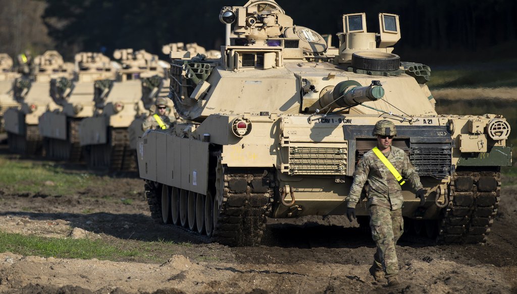 A U.S. Army soldier walks near M1 Abrams battle tanks after arriving at the Pabrade railway station in 2019 in Lithuania, where the U.S. was planning a large military exercise. (AP Photo/Mindaugas Kulbis)