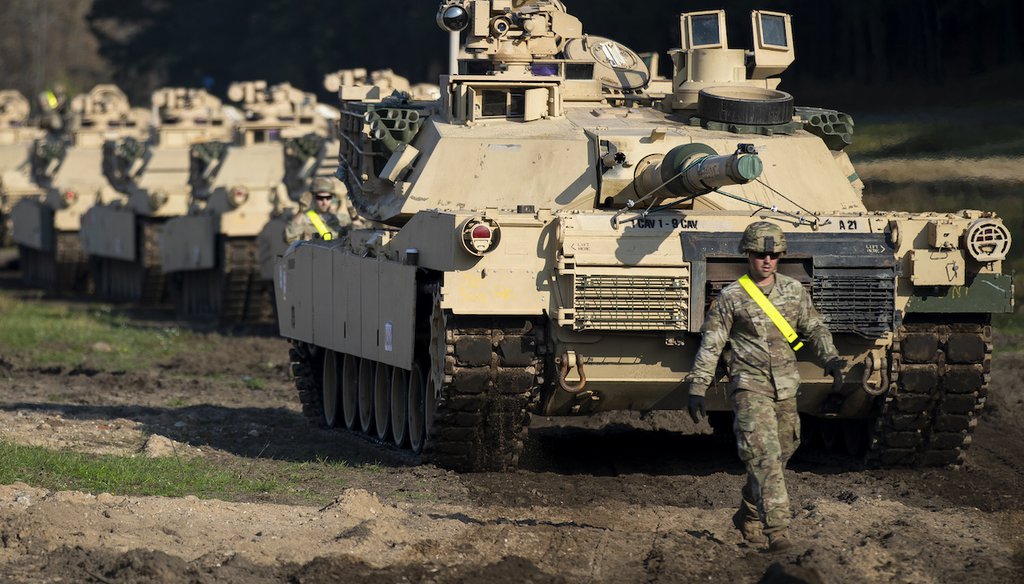 A U.S. Army soldier walks near M1 Abrams battle tanks after arriving at the Pabrade railway station in 2019 in Lithuania, where the U.S. was planning a large military exercise. (AP Photo/Mindaugas Kulbis)