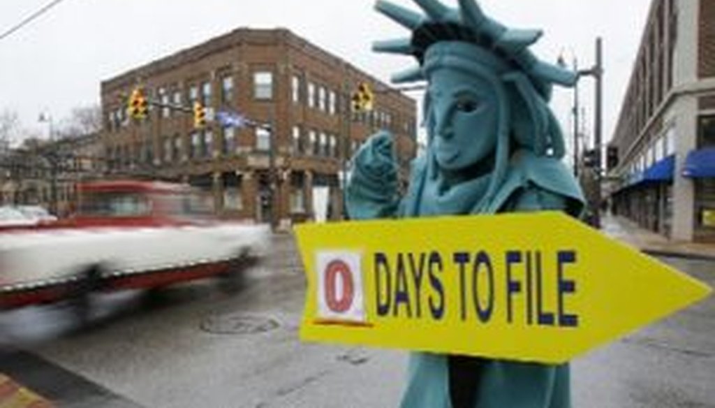 Max Martinez, dressed as the Statue of Liberty, tries to alert motorists on the final day to file taxes Monday, April 18, 2011, in Cleveland. 