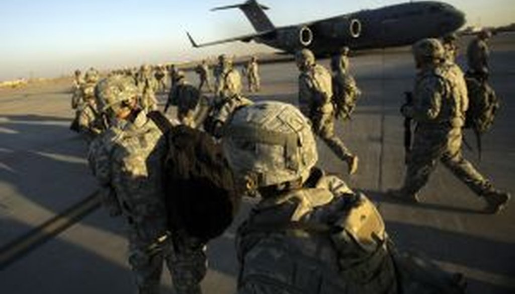 Troops walk toward a C-17 aircraft at Sather Air Base in Iraq. (2010 AP Photo)