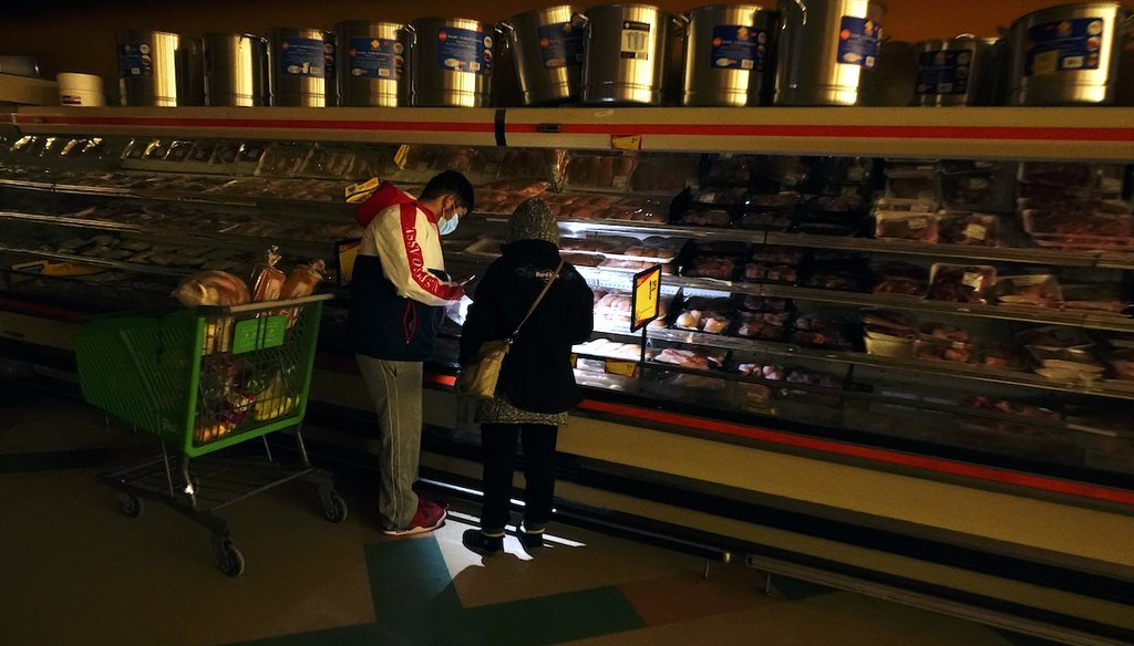 Customers use the light from a cell phone at a grocery store in Dallas that lost power during winter storms, Feb. 16, 2021. (AP)