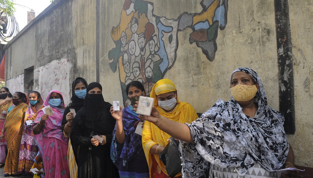 Indian women display identity cards as they wait to cast their votes at a polling station during the last phase of West Bengal state elections in Kolkata, India, on April 29, 2021. (AP)