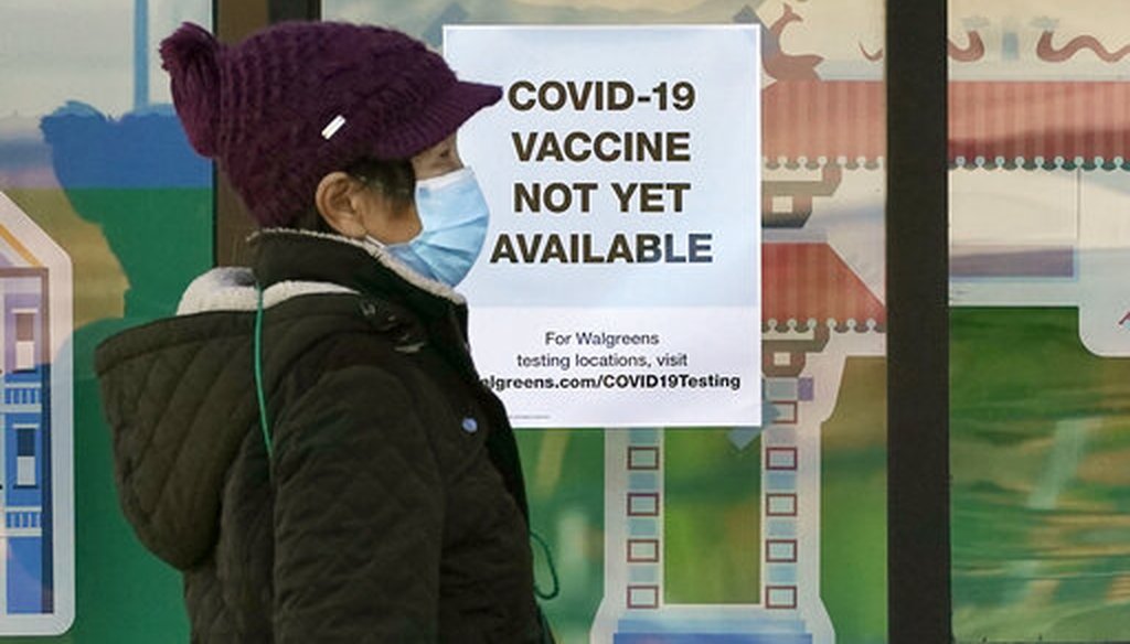 A pedestrian wearing a mask walks past a sign advising that COVID-19 vaccines are not available yet at a Walgreen's pharmacy store during the coronavirus outbreak in San Francisco, Wednesday, Dec. 2, 2020. (AP)