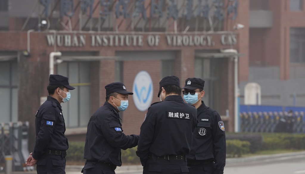 Security personnel gather near the entrance of the Wuhan Institute of Virology during a visit by the World Health Organization team in Wuhan in China's Hubei province, Feb. 3, 2021. (AP)