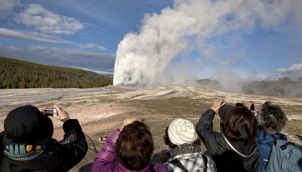 Tourists photograph the Old Faithful geyser erupting in 2011 at Yellowstone National Park, in Montana. Old Faithful is among the park’s hydrothermal features powered by the Yellowstone volcano. (AP Photo/Julie Jacobson)