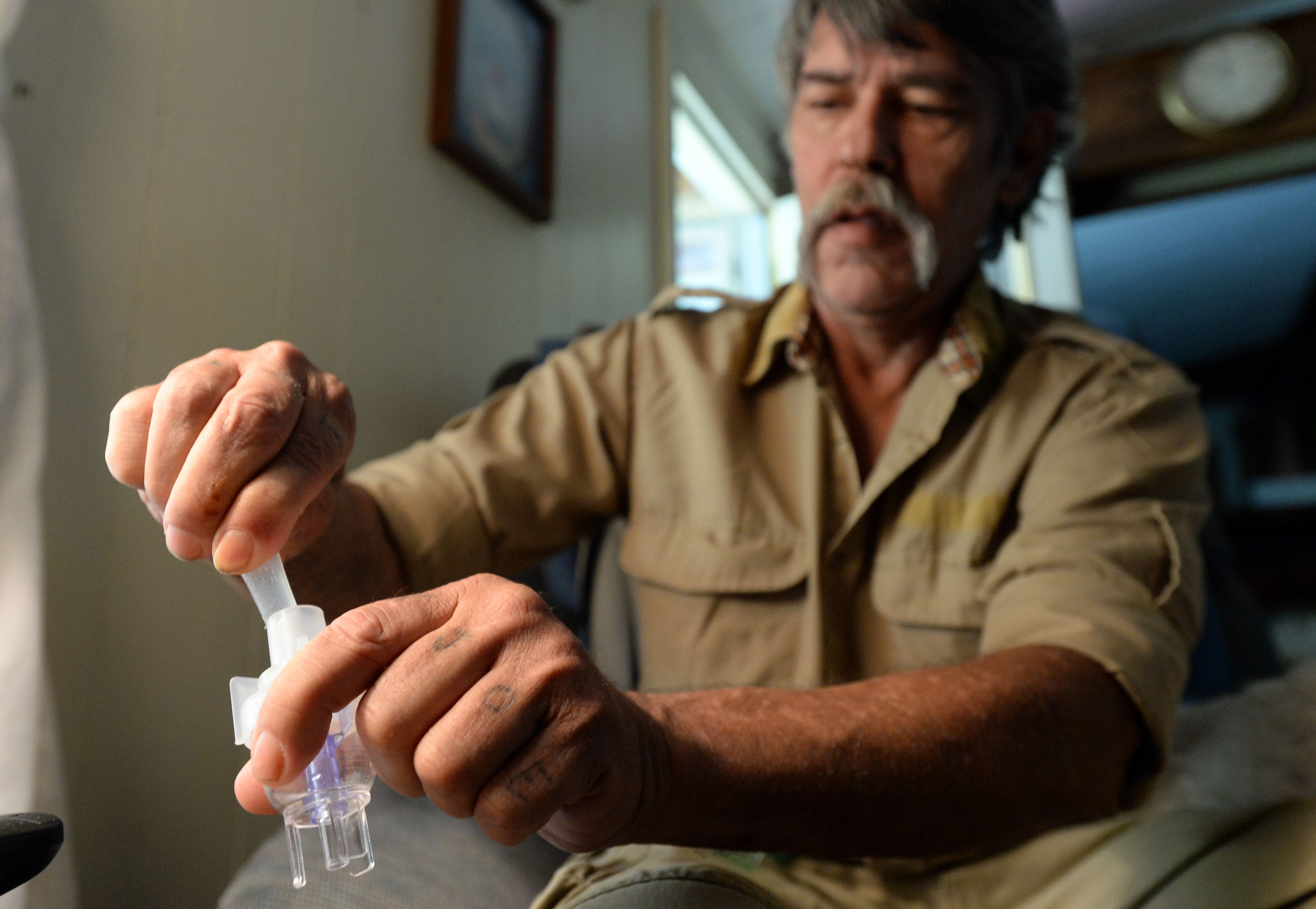 Dale Zipperer is a military veteran without insurance who suffers from chronic bronchitis and emphysema. He prepares to take albuterol sulfate inhalation solution using a Misty-Neb nebulizer for his medical care. Photo credit: Hyosub Shin/AJC.