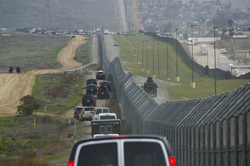 A motorcade carrying President Donald Trump drives along the border before look at border wall prototypes, Tuesday, March 13, 2018, in San Diego. (AP Photo/Evan Vucci)