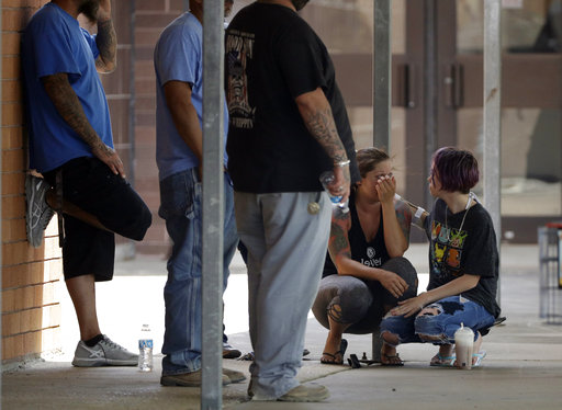 People react outside the unification center at the Alamo Gym, following a shooting at Santa Fe High School Friday, May 18, 2018, in Santa Fe, Texas. (AP Photo/David J. Phillip)