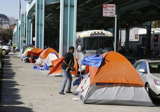 A man stands outside his tent in San Francisco in 2016 in a neighborhood with many homeless people. (AP)