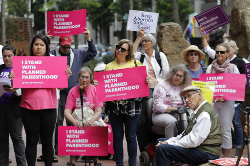 Protesters hold signs supporting Planned Parenthood in Seattle on July 10, 2018. (AP/Ted S. Warren)