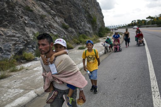 Honduran migrant Jose Macy carries his four-year-old nephew Yair Perez as the thousands-strong caravan of Central Americans migrants hoping to reach the U.S. border moves onward from Juchitan, Oaxaca state, Mexico, on Thursday, Nov. 1, 2018. (AP)