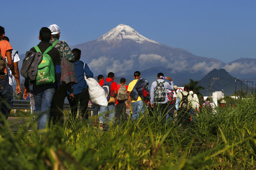 Central American migrants begin their morning trek as part of a thousands-strong caravan hoping to reach the U.S. border, as they face the Pico de Orizaba volcano upon departure from Cordoba, Veracruz state, Mexico, Nov. 5, 2018. (AP Photo/Marco Ugarte)