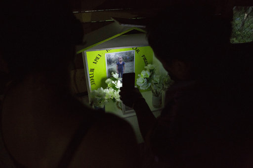 Neighbors illuminate a memorial of Jakelin Caal Maquin at her grandfather's house in San Antonio Secortez, Guatemala, Sunday, Dec. 23, 2018. (AP Photo/ Oliver de Ros)