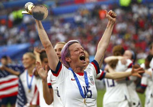 A celebrating Megan Rapinoe holds the Women's World Cup trophy at the Stade de Lyon in Decines, France, on July 7, 2019. (AP)