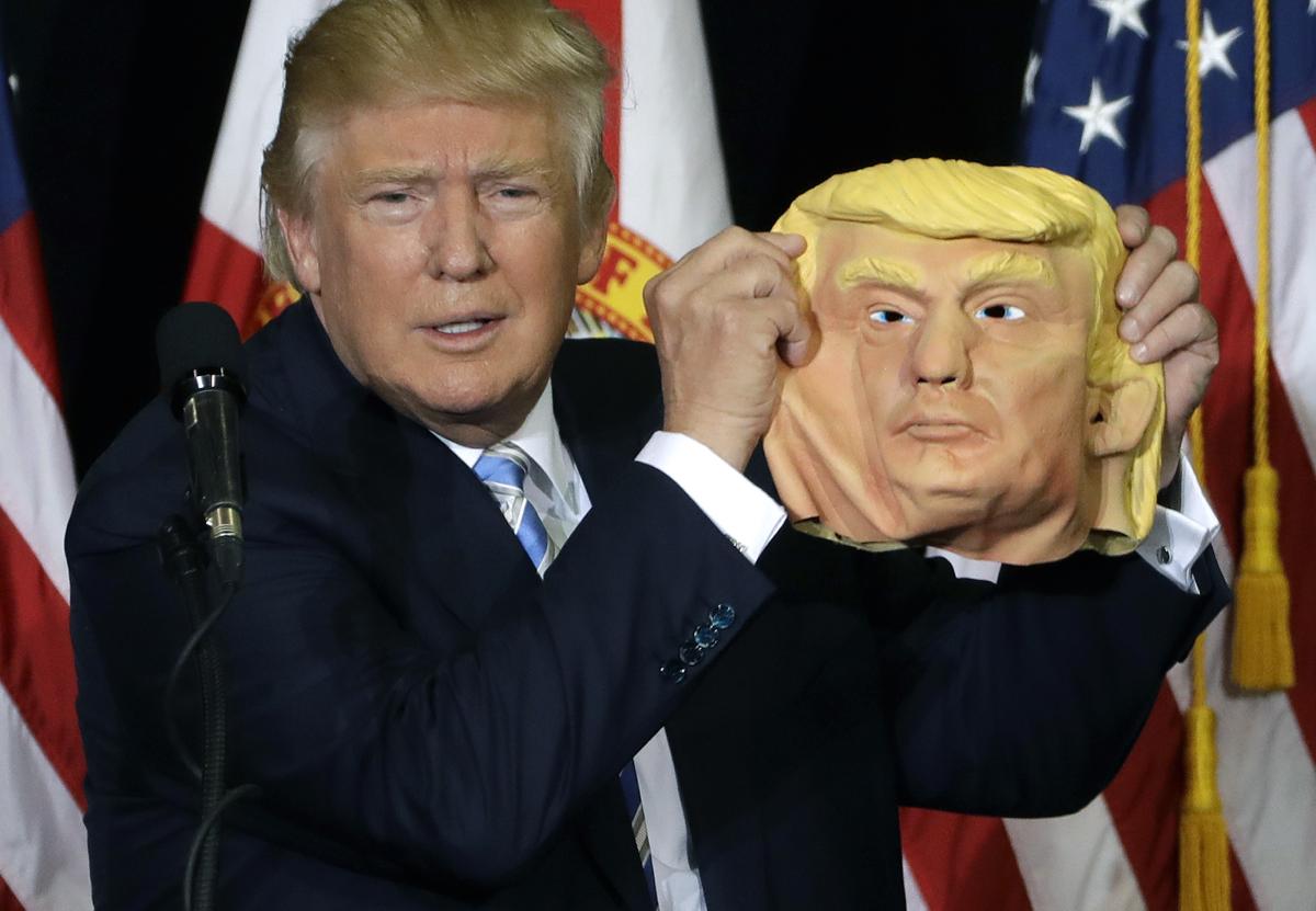 Republican presidential candidate Donald Trump holds up a Donald Trump mask during a campaign speech, Monday, Nov. 7, 2016, in Sarasota, Fla. (AP Photo/Chris O'Meara)