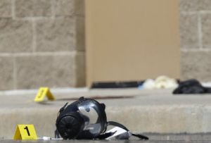 Yellow markers sit next to evidence, including a gas mask, as police investigate the scene outside the Century 16 movie theater east of the Aurora Mall in Aurora, Colo., the site of one of the deadliest mass shootings in recent U.S. history.