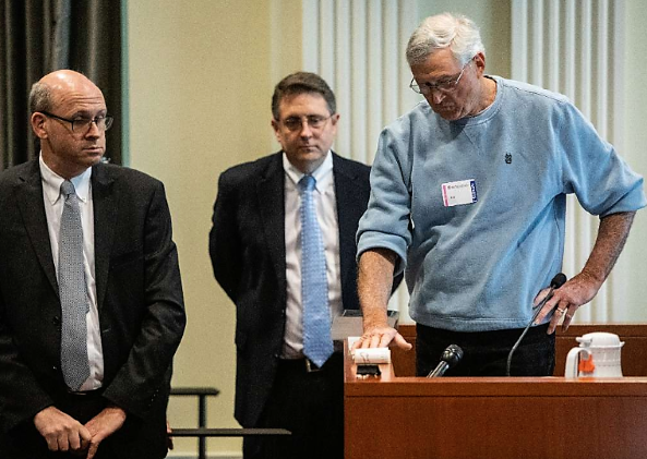 Coy Mitchell Edwards, a Bladen County poll worker, right, looks over a tape that showed early voting results during the second day of a public evidentiary hearing on the 9th Congressional District voting irregularities investigation Feb. 19, 2019 .