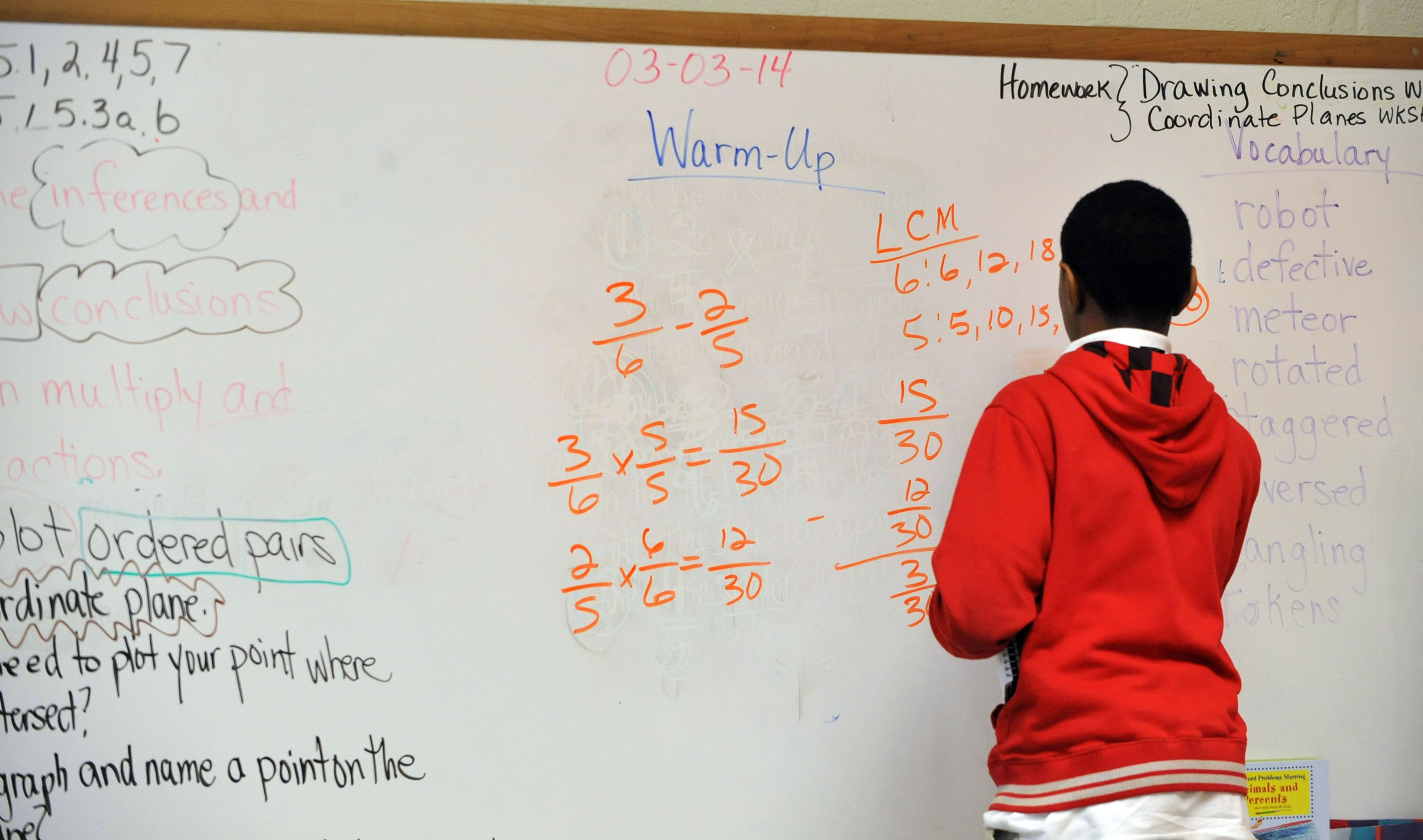 Fifth-grade student Tracey Bridges works a problem on the board at Venetian Hills Elementary School Monday, March 3, 2014. KENT D. JOHNSON / KDJOHNSON@AJC.COM
