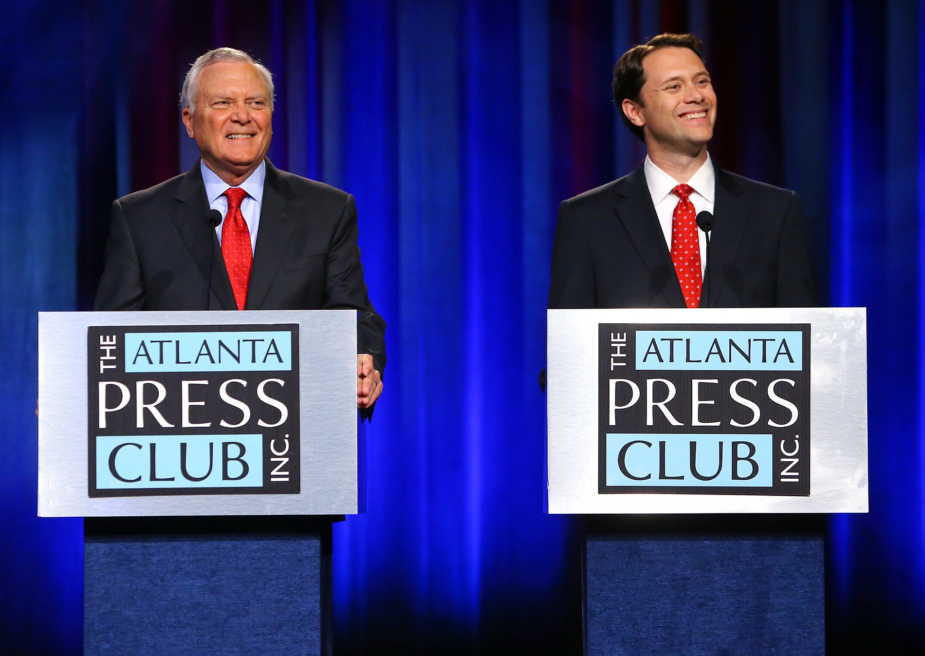 Republican Gov. Nathan Deal, left, and his Democratic rival, state Sen. Jason Carter, smile at a question during the Atlanta Press Club debate on Oct. 19. CURTIS COMPTON PHOTOS / AJC