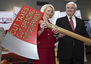 Former House Speaker Newt Gingrich, with his wife Callista, holds an oversize replica of an ax after signing a pledge to cut government Oct. 25 in Concord, N.H.