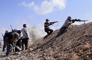 Libyan rebel fighters fire their machine guns towards pro-Gadhafi forces. The U.S. and NATO are enforcing a no-fly zone.