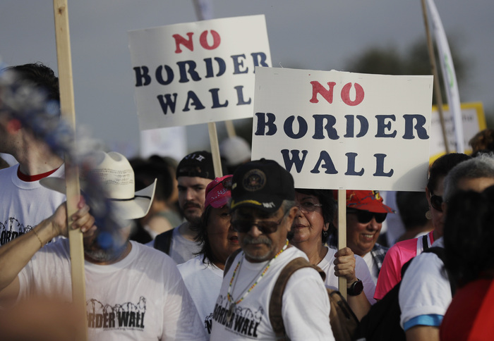 Hundreds of people march along a levee toward the Rio Grande to oppose the wall the U.S. government wants to build on the river separating Texas and Mexico, Saturday, Aug. 12, 2017, in Mission, Texas. (AP Photo/Eric Gay)