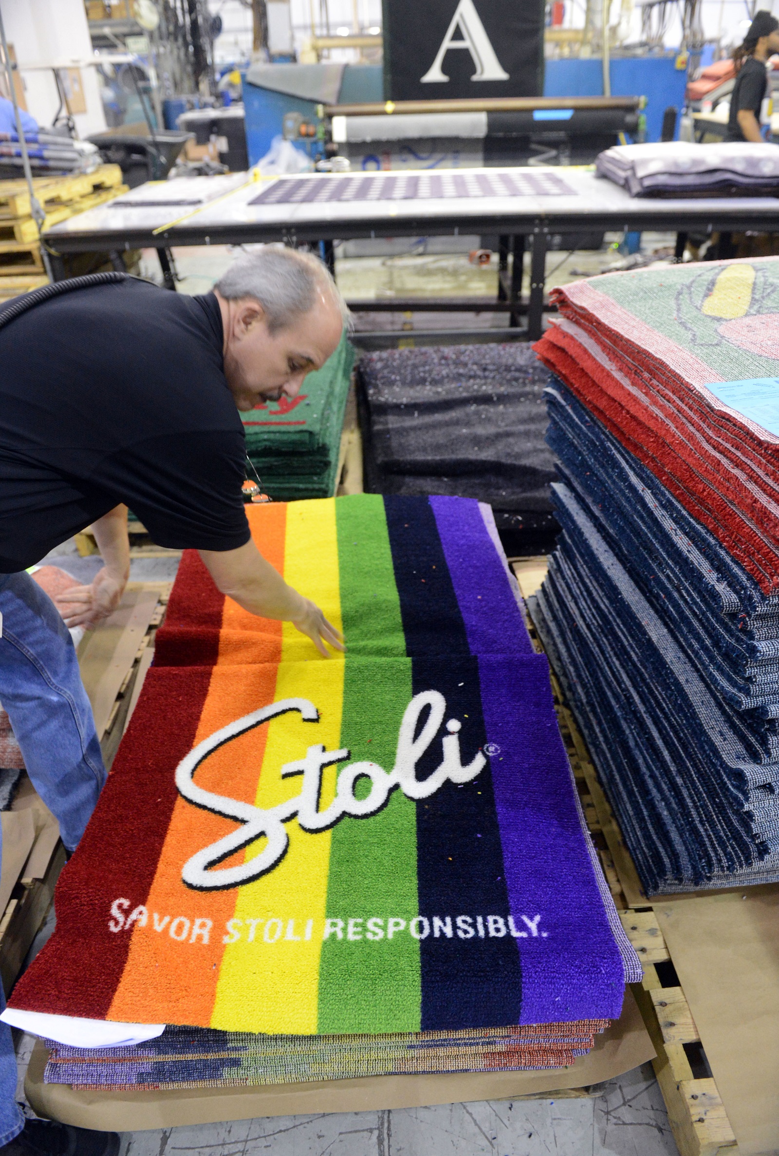A production manager at Millennium Mats checks one of the printed products at its Suwanee plant in 2012, after the firm reversed its outsourcing efforts and shifted work back to the U.S. from China. Photo by Kent D. Johnson/ AJC.