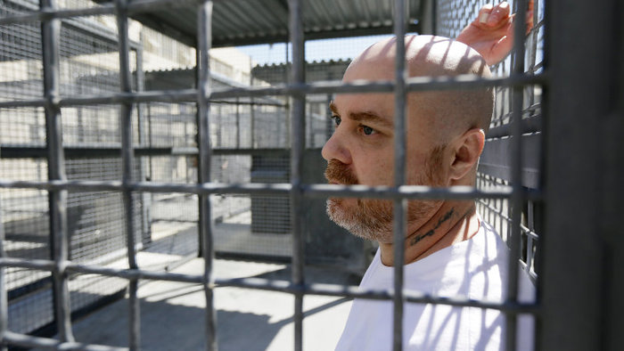 Joseph Perez talks with reporters while standing inside his caged exercise area of the adjustment center on death row at San Quentin State Prison Tuesday, Aug. 16, 2016, in San Quentin, Calif. (AP Photo/Eric Risberg)