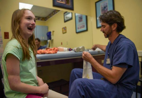 Thirteen-year-old Marina Khimko laughs while waiting for Jason Myers to prepare her prosthetic legs for a fitting at the Shriners Hospital for Children's Pediatric, Orthotic, and Prosthetic Services in Tampa, Fla. (Andres Leiva/Tampa Bay Times)