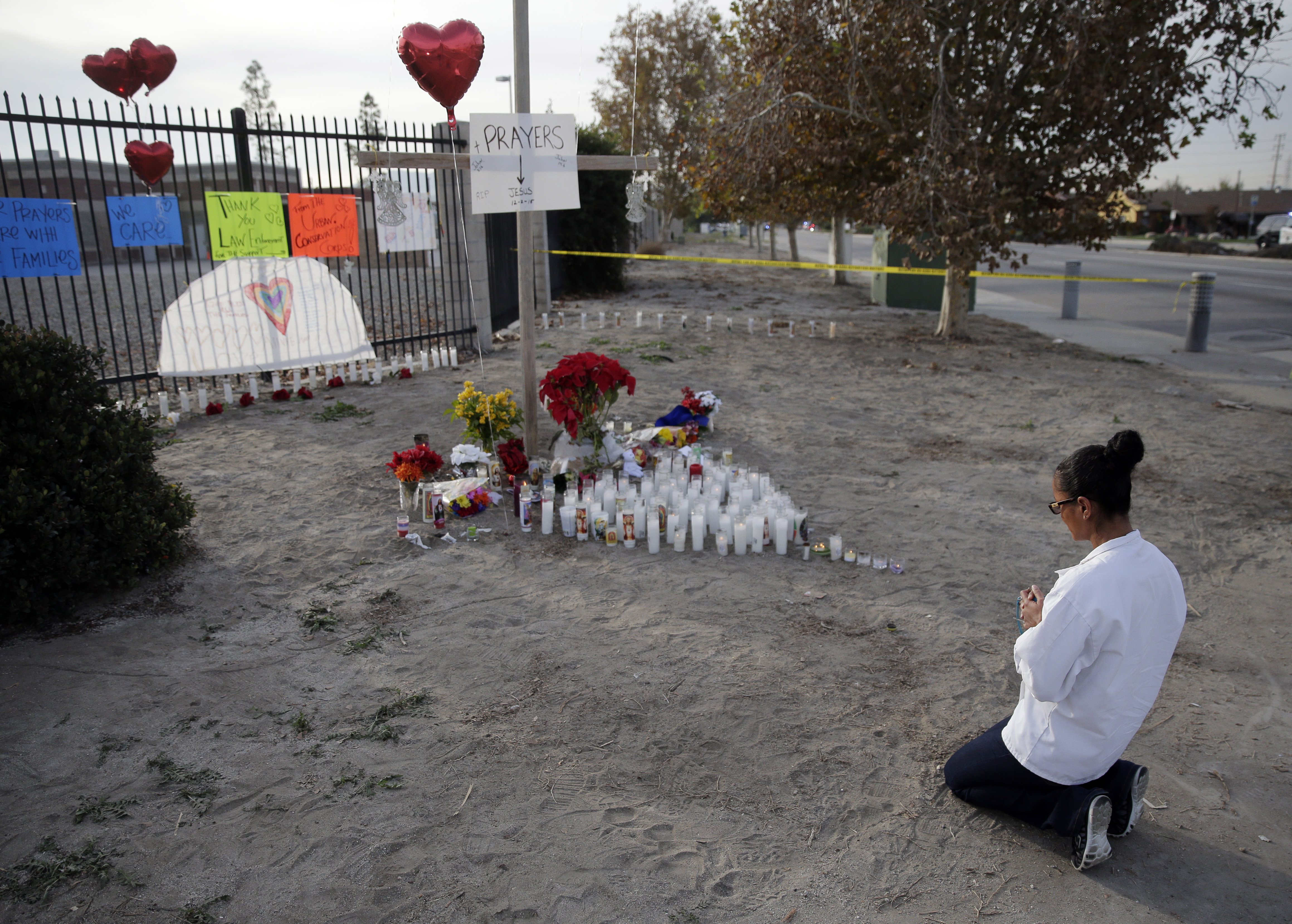 A woman prays at a makeshift memorial on Friday, Dec. 4, 2015, in San Bernardino, Calif., where a husband and wife gunned down 14 people at a holiday office party. (AP)