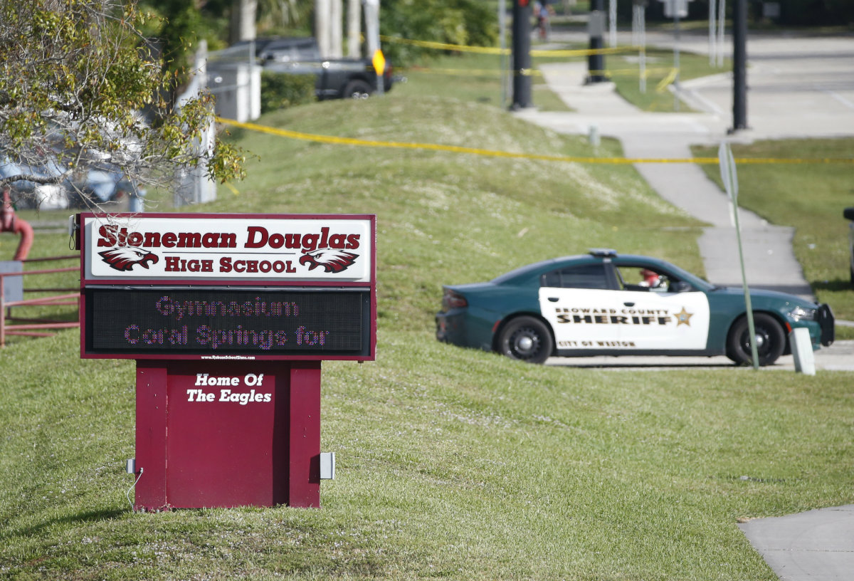 Law enforcement officers block off the entrance to Marjory Stoneman Douglas High School, Thursday, Feb. 15, 2018 in Parkland, Fla. (AP Photo/Wilfredo Lee)