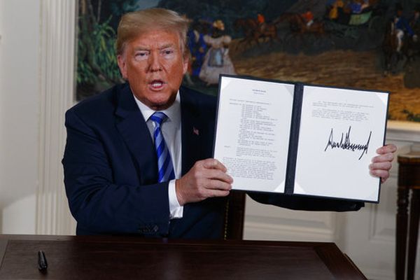 President Donald Trump shows a signed presidential memorandum after delivering a statement on the Iran nuclear deal from the White House on May 8, 2018. (AP/Evan Vucci)