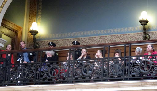 In silent protest, opponents of a series of Republican-backed bills dealing with abortions hold their hands over their mouths while watching debate in the state Assembly on June 13, 2013. AP photo by Scott Bauer