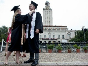 Annelise Schuessler adjusts the cap and gown of fellow graduate Garrett Dee at the May commencement celebration at the University of Texas at Austin, an institution not listed among those with $10,000 degrees. (Andy Sharp, for Austin American-Statesman).