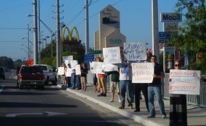 Demonstrators rally along a busy road in Tampa, Fla., to protest the Obama administration's energy policies.