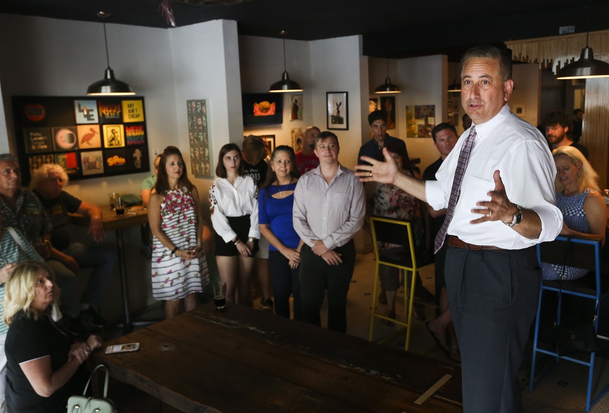 St. Petersburg Mayor Rick Kriseman (right) stands up on a bench as he greets customers and supporters while talking about the stakes in the election during a campaign style stop at Cycle Brewing in St. Petersburg on June 6. (DIRK SHADD | Tampa Bay Times)